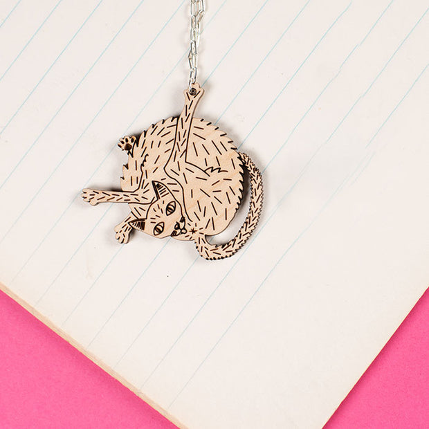wood cat necklace styled on notebook paper